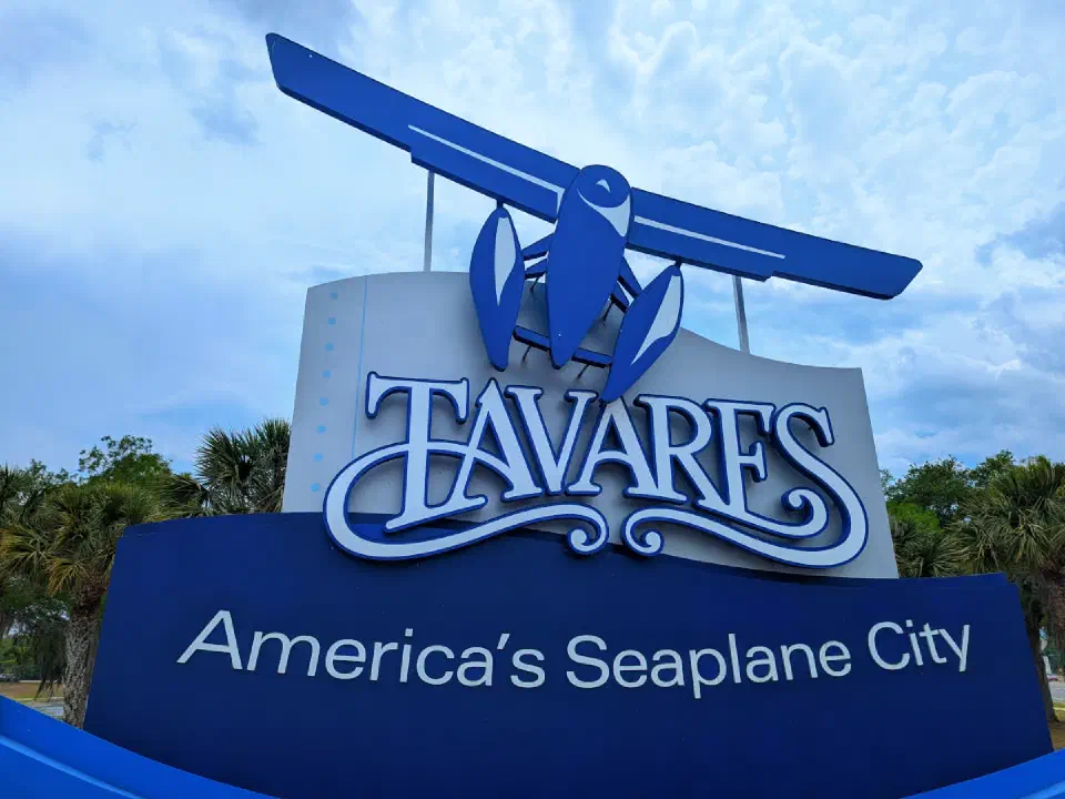 Letrero de bienvenida de la ciudad de Tavares, Florida, con el emblema de un hidroavión.